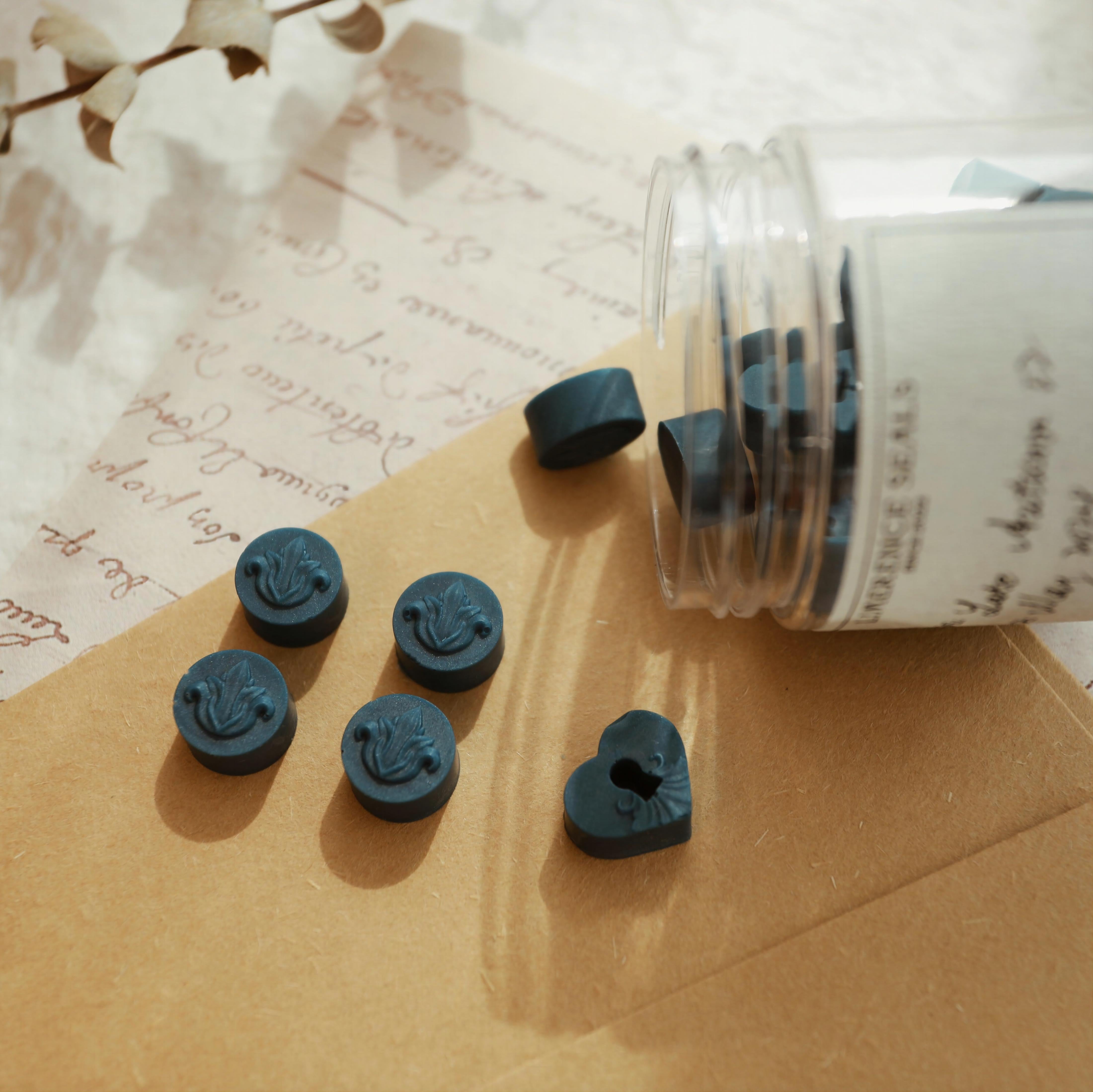 LimerenceSeals 'Late Autumn' handmade blue sealing wax beads scattered on a brown envelope and vintage-style paper. The wax beads feature round and heart shapes with intricate relief designs, perfect for sealing letters and creative crafts.