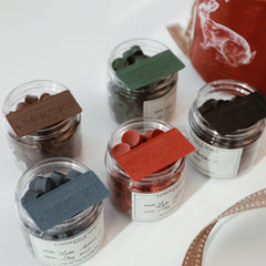 LimerenceSeals 'Late Autumn' handmade sealing wax beads in a variety of colors including brown, green, red, blue, and black. Each jar is labeled with the LimerenceSeals logo, showcasing the brand's commitment to quality and elegance. Ideal for sealing envelopes and crafting projects.