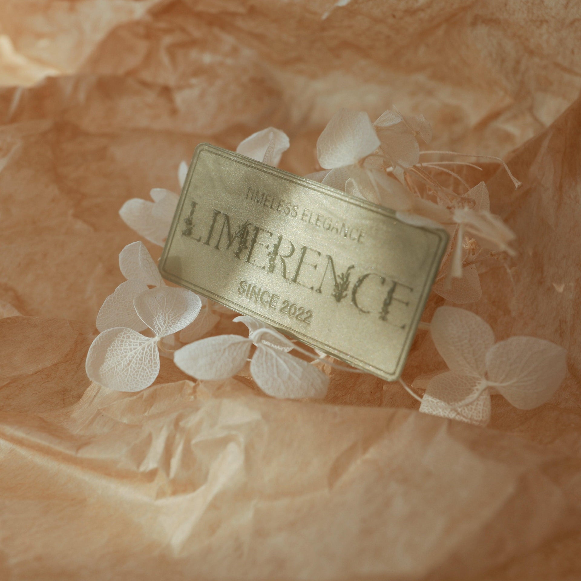 A jade green wax plaque engraved with 'LimerenceSeals Timeless Elegance Since 2022,' placed against a background of soft brown paper and white dried flowers. The intricate design of the wax plaque complements the natural elements, creating an elegant and natural atmosphere, perfect for brand display and high-end decoration.