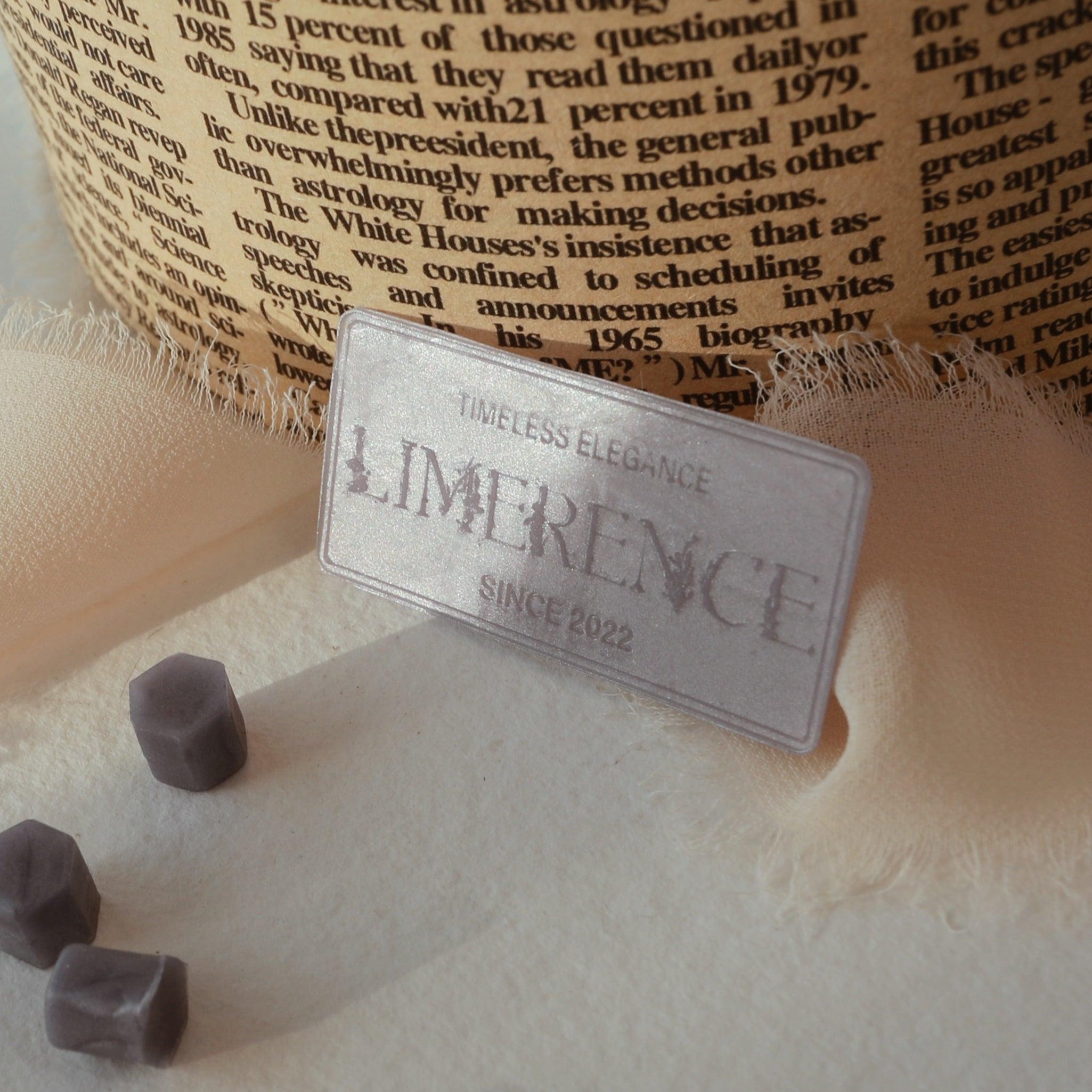 A twilight blue wax plaque engraved with 'LimerenceSeals Timeless Elegance Since 2022,' placed on soft beige fabric. The background features a text-printed paper roll, with a few twilight blue sealing wax beads scattered beside, creating an elegant and vintage atmosphere, perfect for brand display and creative design.