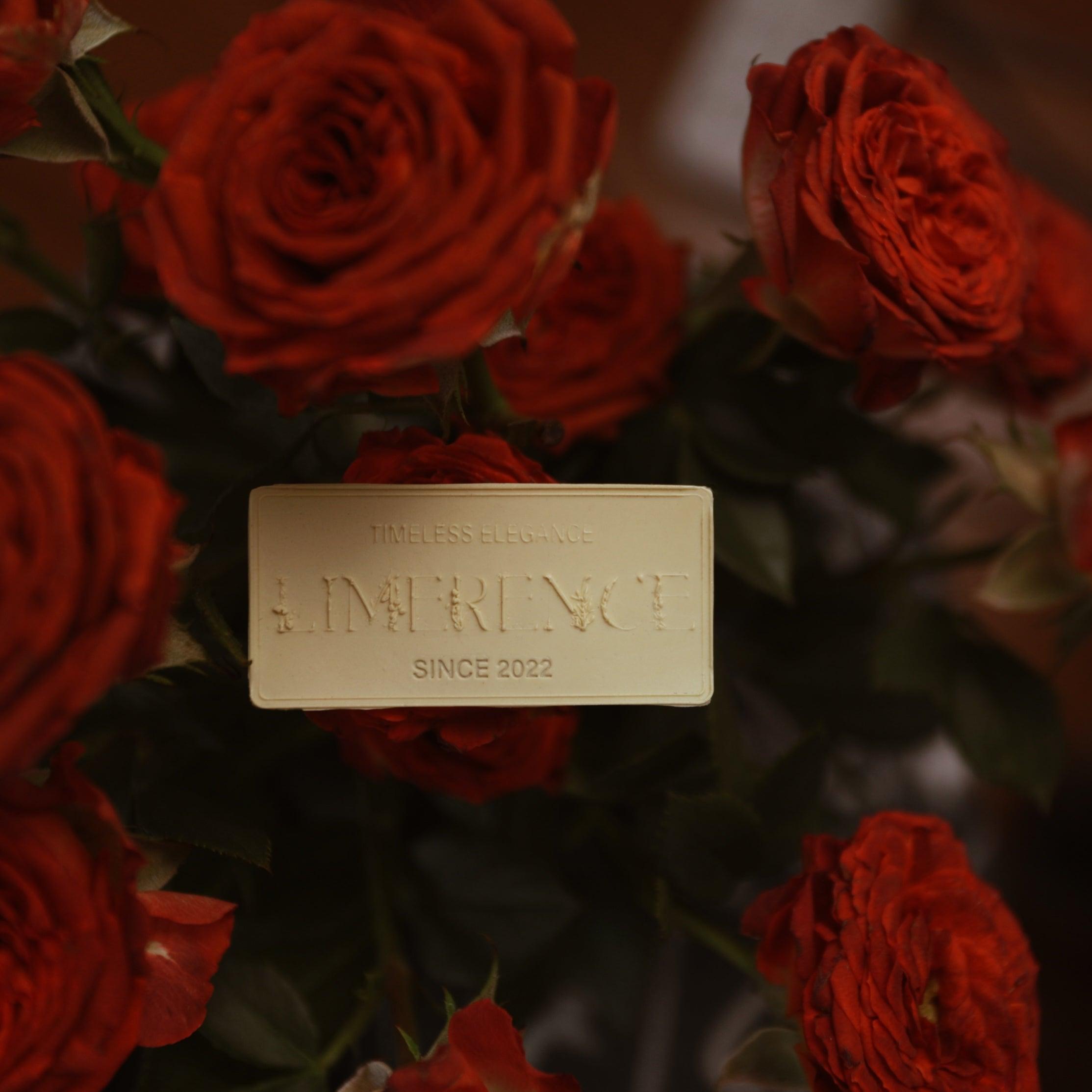 Close-up of a Limerence Seals label embossed with "TIMELESS ELEGANCE - LIMERENCE - SINCE 2022" set against a background of lush red roses. The label in ginger yellow complements the deep hues of the roses, reflecting the brand's commitment to elegant design and quality craftsmanship, perfect for luxury gift presentations.